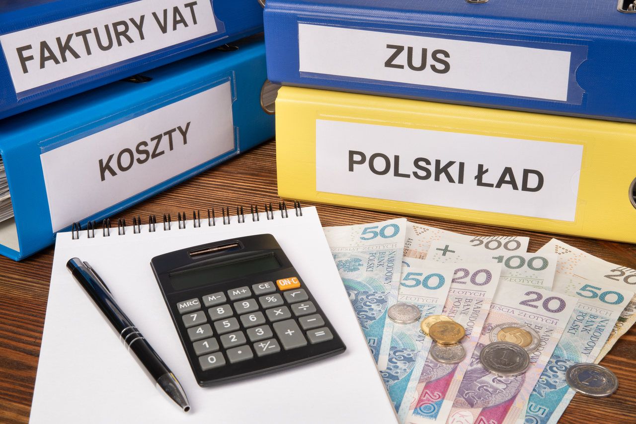 Polski Ład — segregatory, kalkulator i pieniądze w polskiej walucie rozłożone na biurku